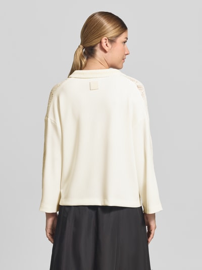 Frauenmodel trägt Strickpullover mit Stehkragen und V-Ausschnitt von Marc Cain, cremeweiß, lockere Passform, Baumwoll-Mix, Rückansicht.