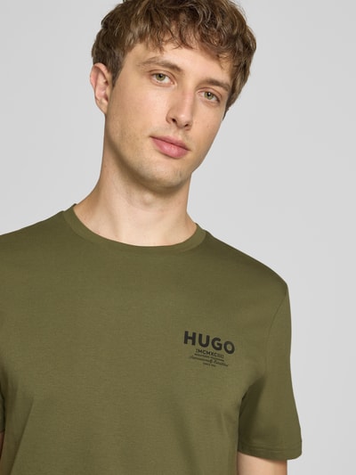 Männermodel trägt Regular Fit T-Shirt aus reiner Baumwolle Modell 'NESPTEE' von HUGO, Heren t-shirt in olijfgroen, Nahaufnahme Oberkörper.
