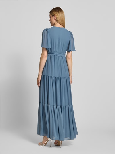 Frauenmodel trägt Abendkleid mit V-Ausschnitt und Bindegürtel von Christian Berg Cocktail, Chiffon, A-Linie, Maxikleid, Stufen-Look, Ganzkörperansicht Rückansicht.