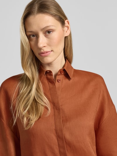 Frauenmodel trägt Boxy Fit Leinenbluse mit 3/4-Arm Modell 'RITO' von MM by Max Mara in rostbraun, Hemdblusenkragen, verdeckte Knopfleiste, reine Leinen-Textur, glatte Oberfläche, Nahaufnahme Oberkörper, Rückenlänge bei Größe 36: 58 cm, Ärmellänge: 27 cm.