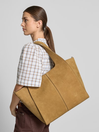 Frauenmodel trägt Tote Bag aus Leder-Mix Modell 'Ramona' von MANGO in Beige mit breitem Schulterriemen, Seitenansicht, Nahaufnahme Oberkörper. Hauptfach mit Magnetverschluss, Maße: 54x33x14 cm, Riemenlänge 62 cm.