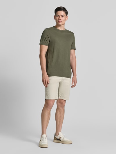 Männermodel trägt Tapered Chinoshorts aus Baumwoll-Mix Modell 'CHINO_TAPERED_DS_3S' von BOSS Orange, Optik: Unifarben, Ganzkörperansicht von vorne.