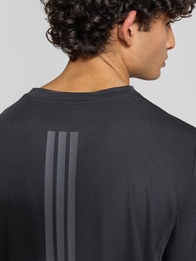 Männermodel trägt Regular Fit Sport T-Shirt mit Label-Print von adidas Training, Optik: Unifarben, Materialverarbeitung: Stretch-Webstruktur, Ganzkörperansicht Rückansicht.