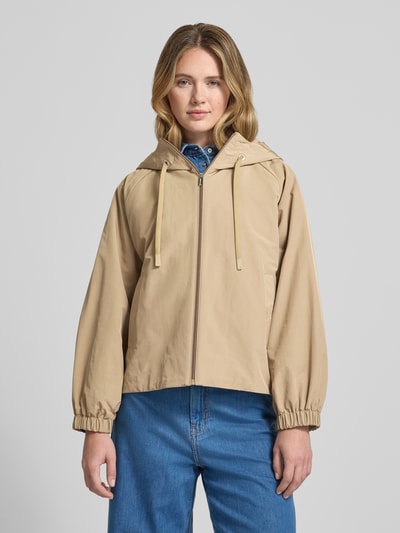 Frauenmodel trägt Relaxed Fit Regenjacke mit Baumwoll-Anteil Modell 'ROMANA' von Weekend Max Mara, beige, Kapuze, Logo-Patch, Ganzkörperansicht von vorne.