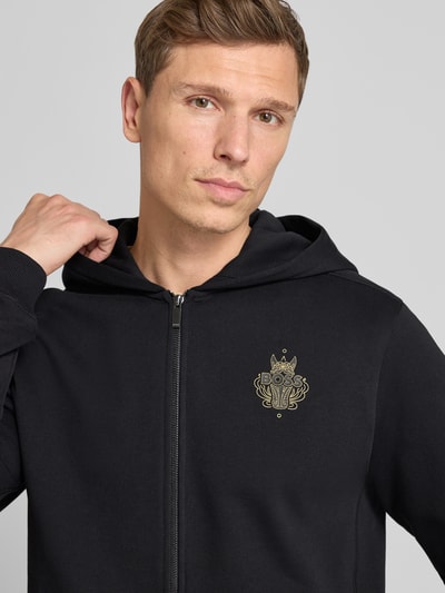 Männermodel trägt Regular Fit Sweatjacke aus reiner Baumwolle Modell 'ZIXI_CNY' von BOSS, Optik: Unifarben, Nahaufnahme Oberkörper.