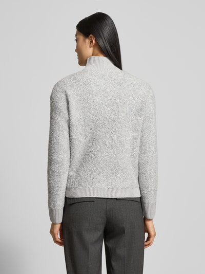 Frauenmodel trägt Strickjacke mit Stehkragen Modell 'Jo44sy' von ZABAIONE, hellgrau meliert, Woll-Mix, lockere Passform, Ganzkörperansicht Rückansicht