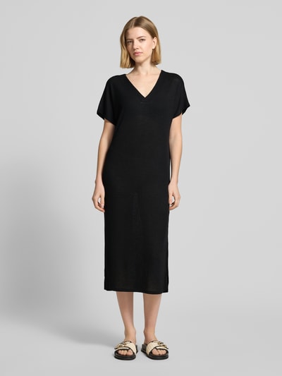 Frauenmodel trägt Strickkleid mit V-Ausschnitt Modell 'Delia' von Soyaconcept in Schwarz, gerader Schnitt, Midilänge, Ganzkörperansicht von vorne. Viskose-Mix mit Stretch-Anteil, kurze Ärmel, glatte Textur, dezente Struktur.