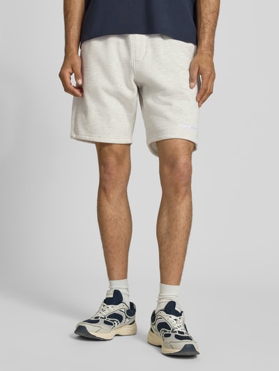 Männermodel trägt Regular Fit Shorts mit Logo-Stitching von Pegador aus Baumwoll-Mix, helle Farbe, elastischer Bund, Nahaufnahme Beine