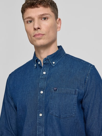 Männermodel trägt Regular Fit Jeanshemd mit Button-Down-Kragen von GAP, aus Baumwoll-Mix mit Stretch-Anteil, Nahaufnahme Oberkörper.