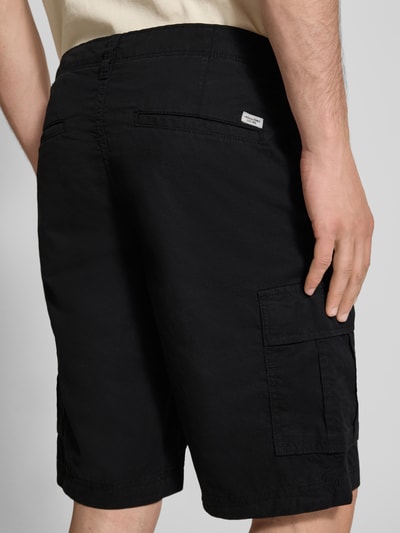 Männermodel trägt Shorts mit Cargotaschen Modell 'COLE MATTY' von Jack & Jones aus Reiner Baumwolle in Schwarz, Regular-Fit, Ganzkörperansicht Rückansicht. Bundweite bei Größe M: 44 cm, Innenbeinlänge bei Größe M: 27 cm.