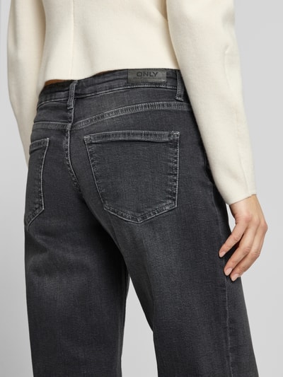 Kobiece modelka nosi Wide Leg Jeans aus Baumwoll-Mix Modell 'JUDY' od Only, denim, jednolity kolor, krój wide leg, niska talia, łatka z logo, szlufki na pasek, zapięcie na guzik i ukryty zamek, fason 5-kieszeniowy, materiał bawełniany, detaliczne ujęcie tylnej części.