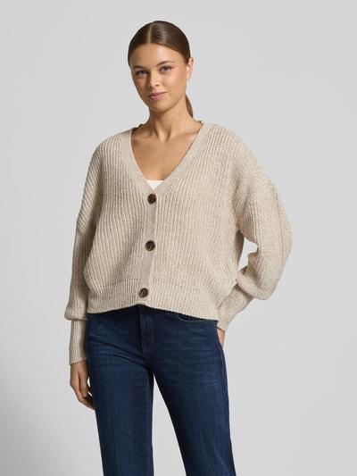 Vrouwenmodel draagt Relaxed Fit Strickjacke met V-hals Model 'LEA' van Vero Moda, melangelook, lange mouwen, geribde boorden, gebreide textuur, eenrijige knopenlijst, oversize schouders, voorkant geheel zichtbaar, vooraanzicht.