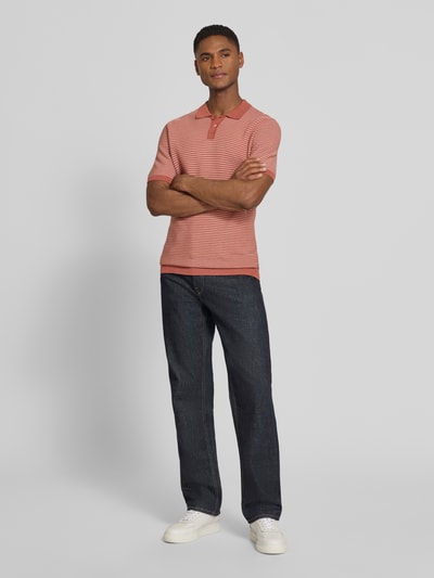 Männermodel trägt Slim Fit Strick-Poloshirt in Two-Tone-Machart Modell 'Triton' von Drykorn, Reine Baumwolle, Ganzkörperansicht von vorne.