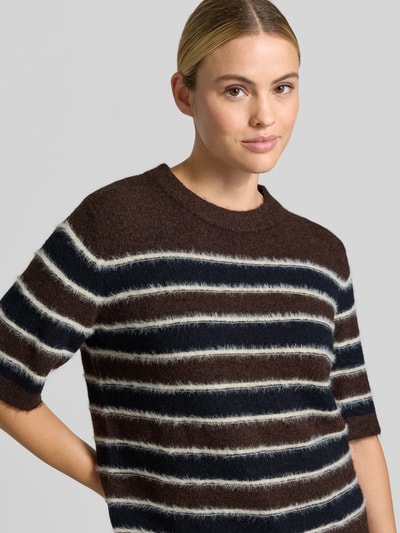 Frauenmodel trägt Loose Fit Pullover mit Mohair-Woll-Anteil Modell 'Pimota Stripe' von OPUS, gestreift in Braun, Dunkelblau und Creme, Stricktextur, Nahaufnahme Oberkörper.