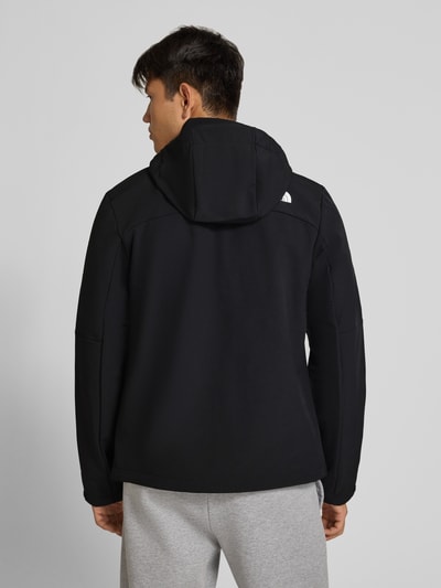 Männermodel trägt czarną Softshell-Jacke mit Logo Modell 'DIABLO' von The North Face, materiał z domieszką stretchu, krój slim fit, kaptur, zamek błyskawiczny, kieszenie na zamek, długość tyłu w rozmiarze M: 68 cm, szerokość ramion w rozmiarze M: 43 cm, szerokość klatki piersiowej w rozmiarze M: 54 cm, długość rękawa w rozmiarze M: 70 cm, widok całej sylwetki z tyłu.
