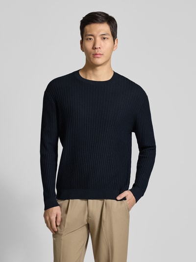 Männermodel trägt Slim Fit Pullover in Strick-Optik von Armani Exchange, reine Baumwolle, Rundhalsausschnitt, elastische Abschlüsse, Ganzkörperansicht von vorne.