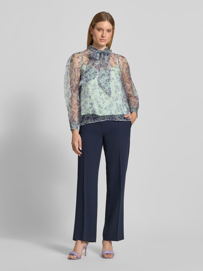 Vrouwenmodel draagt Regular Fit strikblouse uit zijde van Marc Cain, semi-transparant, all-over look, ruglengte maat 36: 63 cm, mouwlengte: 61 cm, Ganzkörperansicht von vorne.