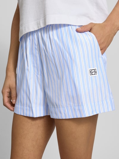 Frauenmodel trägt Shorts mit Label-Detail und elastischem Bund Modell 'FRIDA' von Noisy May, Material-Mix mit Baumwoll-Anteil, Regular-Fit, innenbeinlänge 8 cm, Bundweite 37 cm, Nahaufnahme Oberkörper.