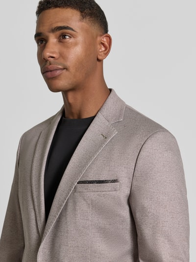 Męski model nosi Regular Fit Anzug mit Viskose-Anteil Modell 'Ponza' von CINQUE, elastyczna mieszanka materiałów, jasny beż, Kołnierz z połami, kieszeń na piersi, listwa z 2 guzikami, Szerokość w rozmiarze 50: 45 cm, Długość tyłu 72 cm, Szerokość ramion 43 cm, Długość rękawów 84 cm; Nahaufnahme górnej części ciała.