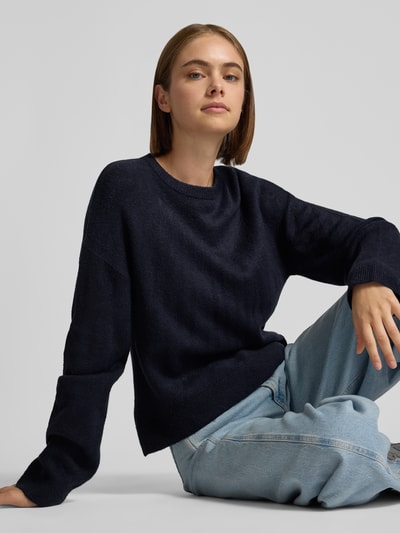 Frauenmodel trägt dunkelblauen Relaxed Fit Pullover mit Rundhalsausschnitt Modell 'SIMONI' von ONLY, Damen Pullover, Nahaufnahme Oberkörper.