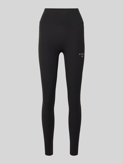 Produktfoto, schwarze Leggings mit elastischem Bund im Modell 'PUMA x HYROX SHAPELUXE' von PUMA, Material-Mix mit Stretch-Anteil, körpernahe Passform, kleines Logo auf dem Bein, glatte Oberfläche.