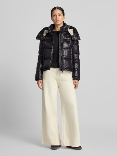 Frauenmodel trägt schwarze Regular Fit Jacke mit Sorona-Füllung Modell 'GLORIA' von Blauer USA in Stepp-Optik, Ganzkörperansicht von vorne.