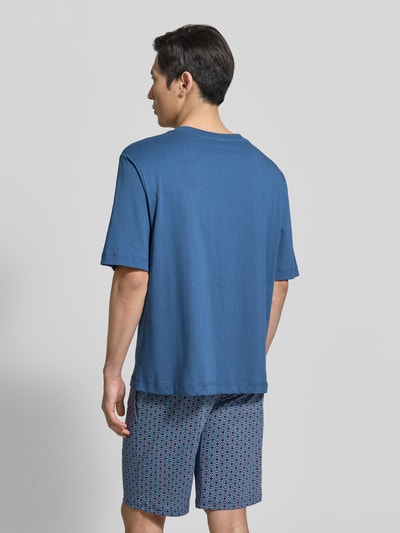 Męski model nosi T-Shirt mit Rundhalsausschnitt und Brusttasche od Schiesser, mieszanka bawełny i lnu, krój regular fit, okrągły dekolt, brustasza, długość tyłu w rozmiarze 50: 70 cm, całkowity widok z tyłu.