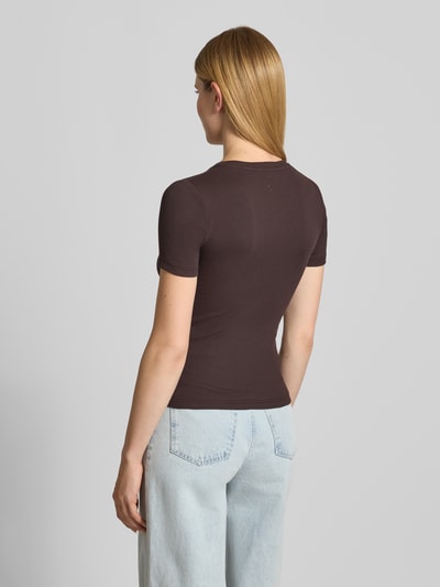 Vrouwenmodel draagt T-shirt met ronde hals model 'ALEXIS' van Samsøe Samsøe, katoen-elastaan mix, slim fit, ruglengte 54 cm, volledige lichaamsopname achteraan.