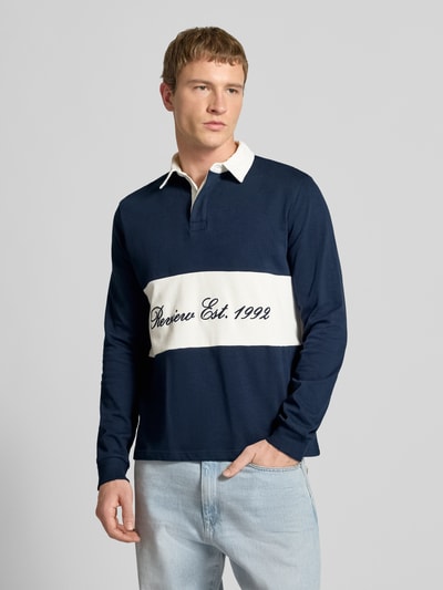 Männermodel trägt Regular Fit Langarm-Poloshirt mit Label-Stitching von REVIEW in Dunkelblau mit weißem Kontraststreifen, Reine Baumwolle, verdeckte Knopfleiste, Rückenlänge 68 cm, Ärmellänge 72 cm, Ganzkörperansicht von vorne.