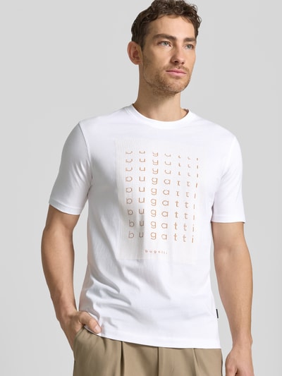 Männermodel trägt Regular Fit T-Shirt mit Logo-Print von bugatti, Herren T-Shirt aus Reine Baumwolle, Rundhalsausschnitt, Ganzkörperansicht von vorne. Rückenlänge bei Größe M: 70 cm.