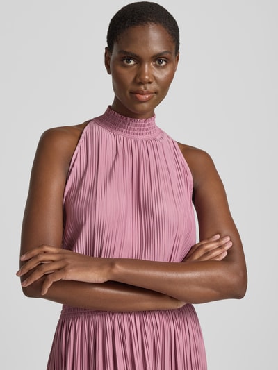 Modelka kobieca nosi Plisseekleid mit Smok-Details Modell 'UMA' od Samsøe Samsøe, różowy materiał z fakturą plisowaną, elastyczny, detal przy szyi, krój dopasowany, długość midi, widok z przodu zbliżenie na górną część ciała.
