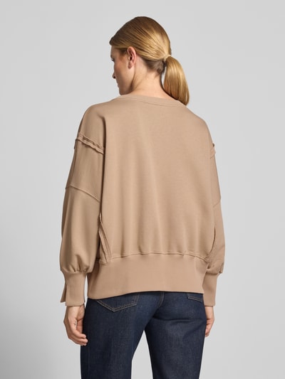 Frauenmodel trägt Oversized Sweatshirt aus reiner Baumwolle mit Statement-Print von miss goodlife in Beige mit Rundhalsausschnitt und elastischen Abschlüssen, Ganzkörperansicht Rückansicht.