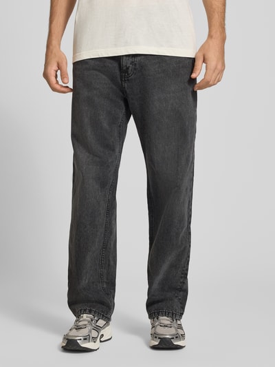 Mężczyzna nosi Baggy Jeans in Grau im klassischen 5-Pocket-Look od REVIEW, szara bawełna, krój baggy, wpuszczane kieszenie, zapięcie na guzik i zamek błyskawiczny, szerokość w rozmiarze 32: 42 cm, długość wewnętrzna nogawki w rozmiarze 32: 77 cm, widok z przodu, zbliżenie na dolną część ciała.