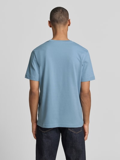Męski model nosi Regular Fit T-Shirt aus Baumwoll-Mix od Tom Tailor, jednolity niebieski, bawełniany piqué, krótkie rękawy, widok całej sylwetki z tyłu.