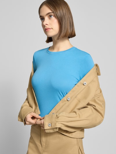 Vrouwenmodel draagt Slim Fit Langarmshirt uit puur katoen van Marc O'Polo Denim, look effen, jersey, ronde hals, labeldetail, nahaufnahme bovenlichaam.