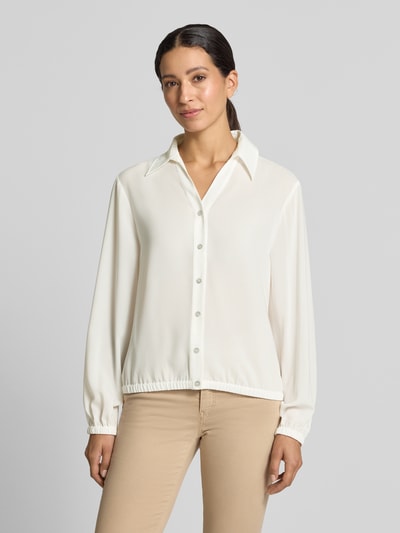 Frauenmodel trägt Regular Fit Bluse mit V-Ausschnitt von Marc Cain in Creme mit Hemdblusenkragen und Knopfleiste, Ganzkörperansicht von vorne.