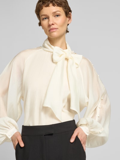 Frauenmodel trägt Blusenshirt aus Lyocell-Mix mit Schal von Copenhagen Muse, Cremefarbe, Knöpfe, Relaxed Fit, Nahaufnahme Oberkörper.