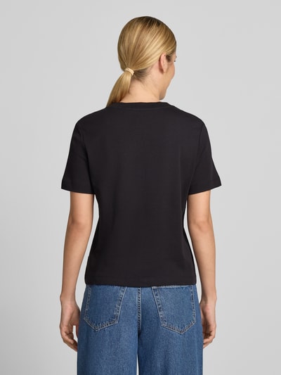 Frauenmodel trägt Regular Fit T-Shirt aus reiner Baumwolle von s.Oliver RED LABEL, schwarz, kombiniert mit blauer Jeans, Ganzkörperansicht Rückansicht.