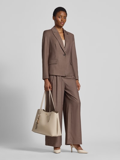 Vrouwenmodel draagt 2-in-1-shopper met uitneembare binnenzak van GUESS in beige, met labelapplicatie, schouderband, magneetsluiting, Hoofdvak, breedte 44 cm, lengte 28 cm, diepte 15 cm, bandlengte 76 cm, model ECO MELODY, Ganzkörperansicht van voren.