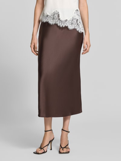 Frauenmodel trägt Midirock aus Satin von Rich & Royal in Braun, glatte Oberfläche, Straight Fit, elastischer Bund, Ganzkörperansicht von vorne.