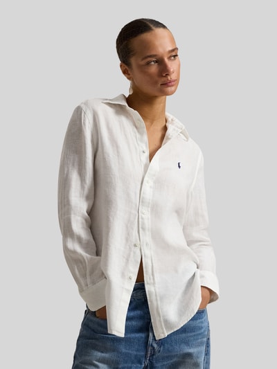 Kobiece modelka nosi Bluzka koszulowa aus reinem Leinen von Polo Ralph Lauren w kolorze białym, luźny krój, kołnierzyk koszulowy, listwa guzikowa, wyhaftowane logo, długość tyłu w rozmiarze S: 70 cm, długość rękawów w rozmiarze S: 58 cm, materiał o widocznej teksturze lnu. Nahaufnahme Oberkörper.