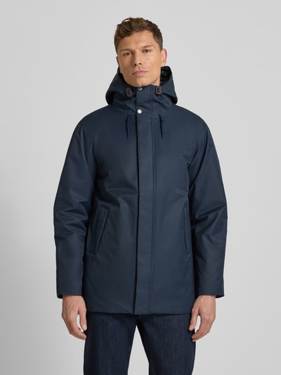 Männermodel trägt Regular Fit Parka aus Baumwoll-Mix von Barbour in Dunkelblau, Optik: Unifarben, wasserabweisend, Ganzkörperansicht von vorne.