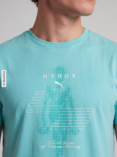 Männermodel trägt Regular Fit Sport-T-Shirt mit Label-Print Modell 'CLOUDSPUN' von PUMA in Hellblau mit weißem Print, Nahaufnahme Oberkörper, Herren Sport-T-Shirt von PUMA Performance, KI-modifiziertes Bild.