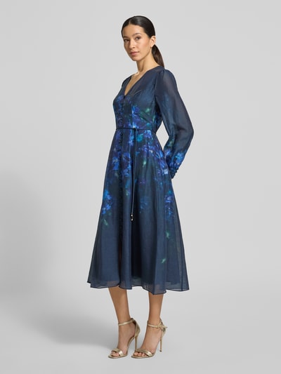 Vrouwenmodel draagt midi-jurk van lyocellmix met linnen, A-lijn, V-hals, knoopsluiting, strikceintuur, model 'Kahlani' van Forever New, donkerblauw met bloemenmotief, volledige lichaamsaanzicht vooraan.