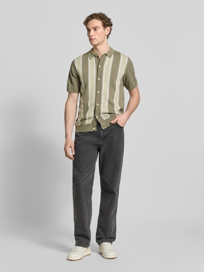 Męski model nosi Polo-Cardigan mit 1/2-Arm od Lindbergh, bawełna, krój regular fit, zapięcie na guziki, szare spodnie, przód, ujęcie całopostaciowe