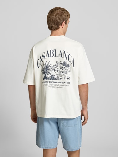Männermodel trägt T-Shirt mit Label-Detail von REVIEW, weiß, Reine Baumwolle, Lockerer-Schnitt, Rückenlänge 68 cm, Ganzkörperansicht Rückansicht.
