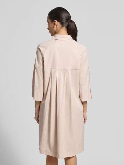 Frauenmodel trägt Hemdblusenkleid mit überschnittenen Schultern von Marc Cain in Beige mit Viskose-Anteil, Gerader-Schnitt, 3/4-Arm, Label-Detail, Rückenlänge 101 cm, Brustweite 53 cm, Ärmellänge 48 cm, Ganzkörperansicht Rückansicht.