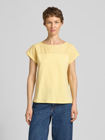 Frauenmodel trägt Regular Fit Blusentop aus reiner Baumwolle Modell 'JANNI' von Vero Moda, Optik: Unifarben, Passform: Regular-Fit, semitransparenter Besatz, U-Boot-Ausschnitt, Ärmelform: Kurzarm, Materialverarbeitung: Jersey, Material: Reine Baumwolle, sanft gelber Ton, glatte Textur, Ganzkörperansicht von vorne.