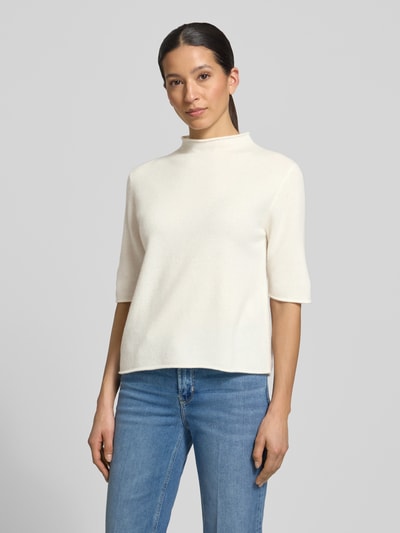 Vrouwenmodel draagt gebreid shirt van zuiver wol, regular fit, model 'Tumea' van Someday met opstaande kraag en rolzoom, ruglengte 52 cm, mouwlengte 34 cm, dames, offwhite kleur, gladde textuur, vooraanzicht bovenlichaam.