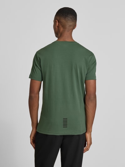 Männermodel draagt T-Shirt met Label-Print van EA7 Emporio Armani, donkergroen, slim fit, katoen-elastaanmix, rugaanzicht, Ganzkörperansicht Rückansicht.